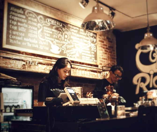 Barista melayani pesanan di meja kasir kedai kopi